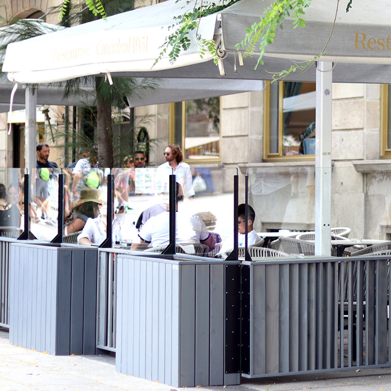 Jardinera de madera fija anclada al suelo con paravientos, ideal para separar espacios en exteriores.