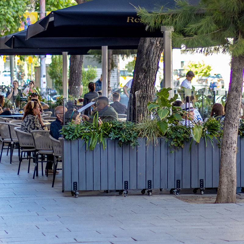 Jardinera de madera con ruedas, ideal para separar espacios en terrazas y jardines. Medidas 100x24x80 cm.