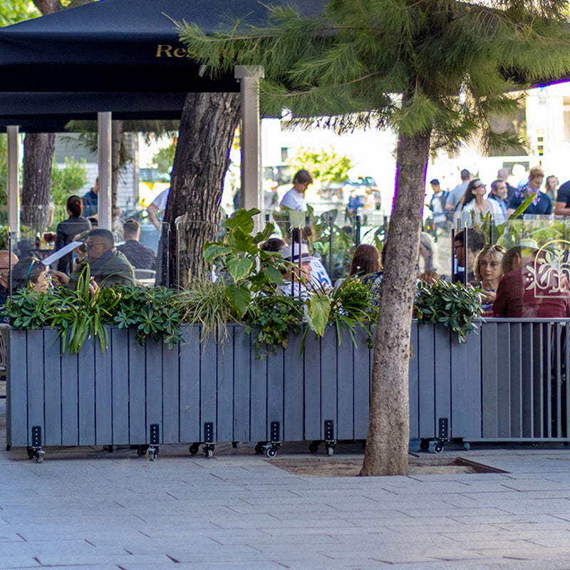 Jardinera de madera fija autoportante con paravientos, ideal para separar espacios en terrazas y jardines.