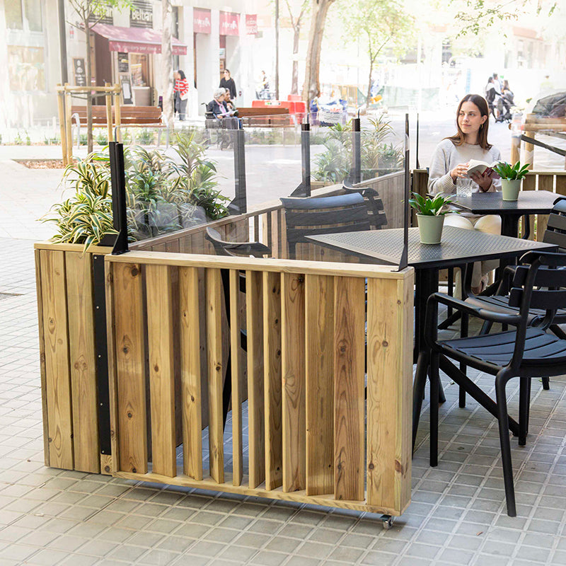 Jardinera de madera fija anclada al suelo con paravientos, ideal para separar espacios en exteriores.