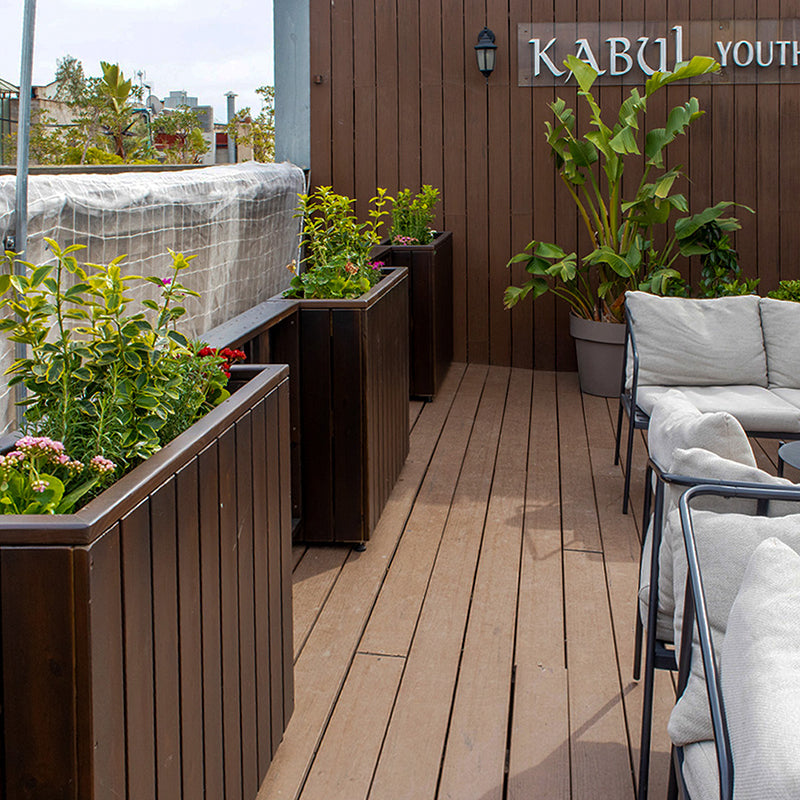 Jardinera de madera fija anclada al suelo, ideal para separar espacios en terrazas y jardines. Dimensiones 75x24x80 cm.